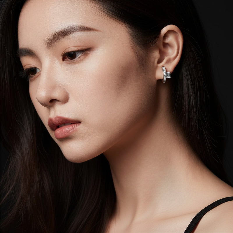 Model wearing emerald accented huggie earrings