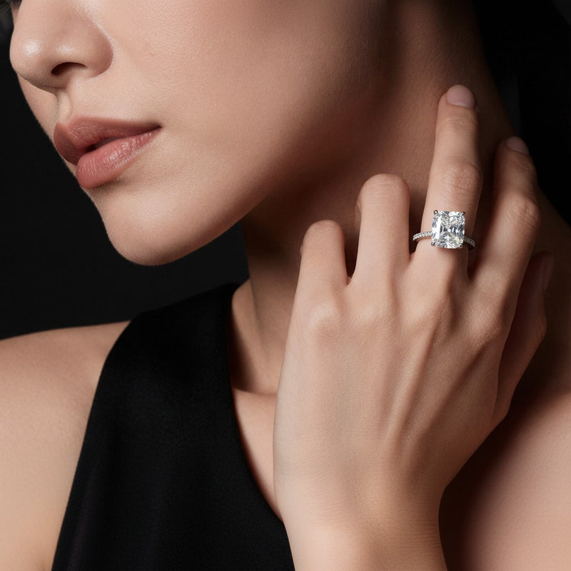 Model wearing cushion accented engagement ring