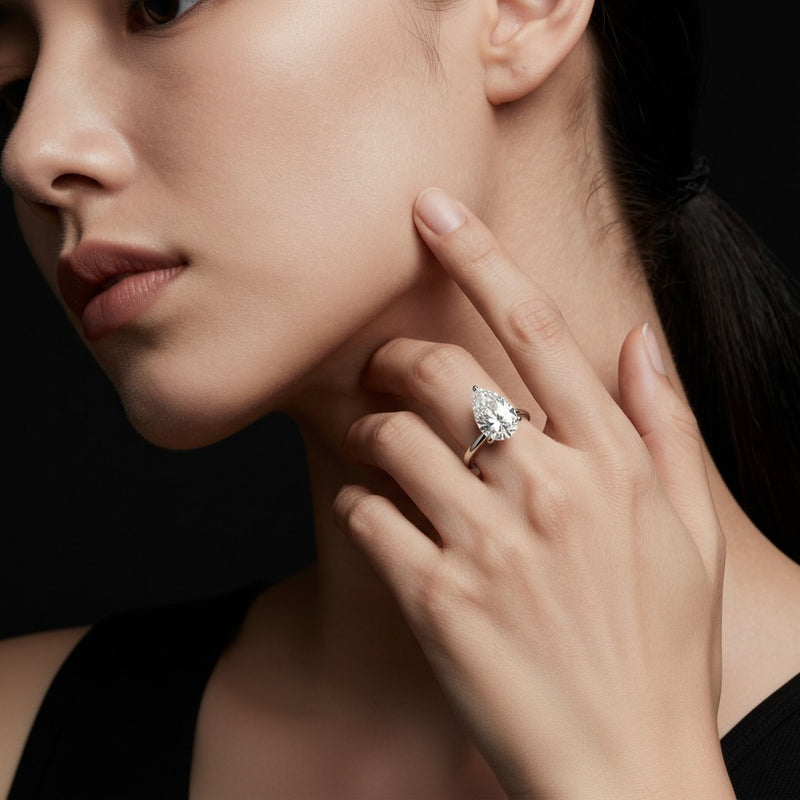 Model wearing pear hidden halo plain shank engagement ring