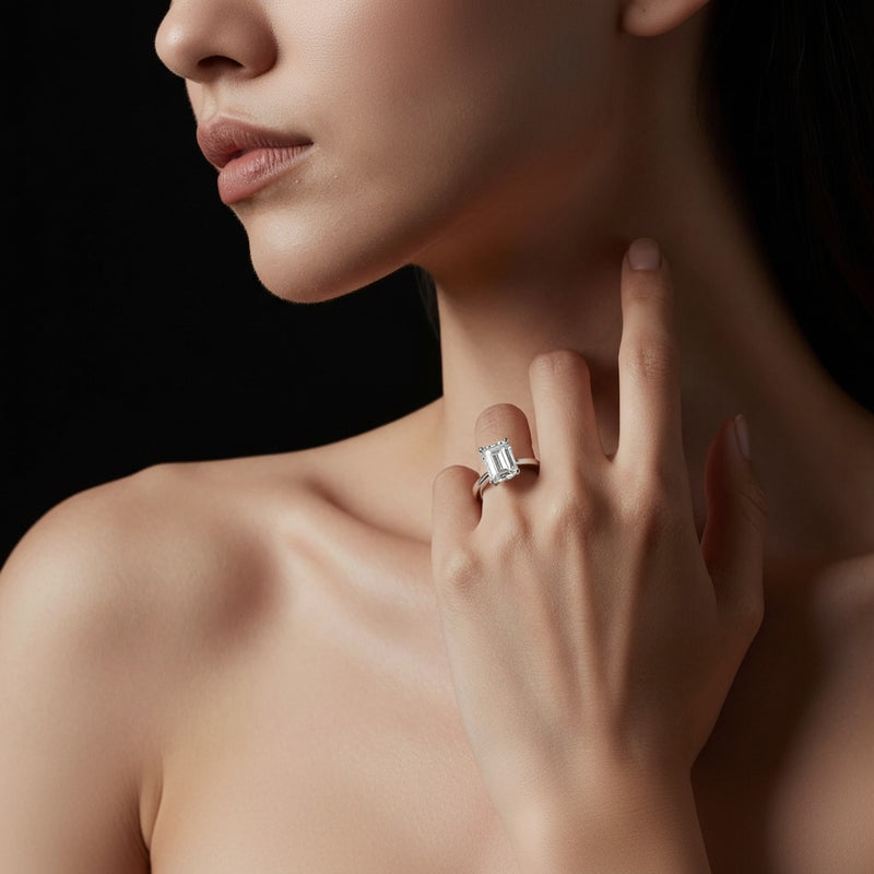 Model wearing emerald hidden halo cathedral shank engagement ring