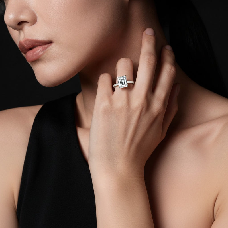 Model wearing emerald hidden halo cathedral shank engagement ring