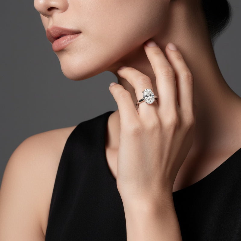 Model wearing oval hidden halo cathedral shank engagement ring