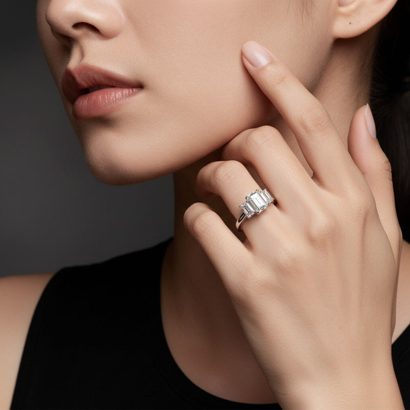 Model wearing emerald three stone accented ring