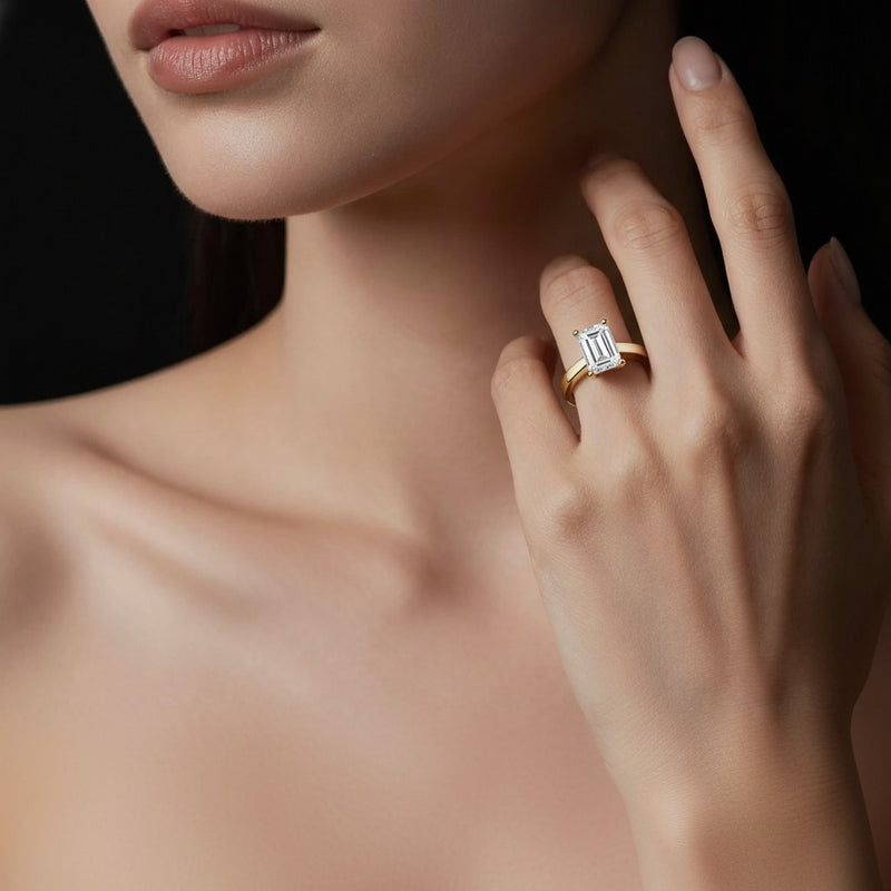 Model wearing emerald two tone twisted basket cathedral shank solitaire ring