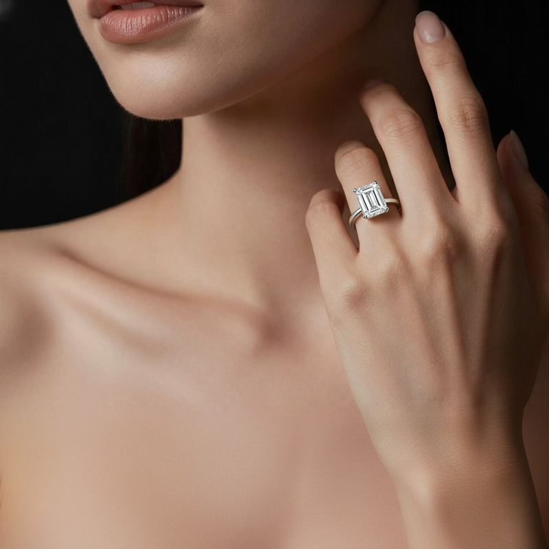 Model wearing emerald knife edge shank solitaire engagement ring