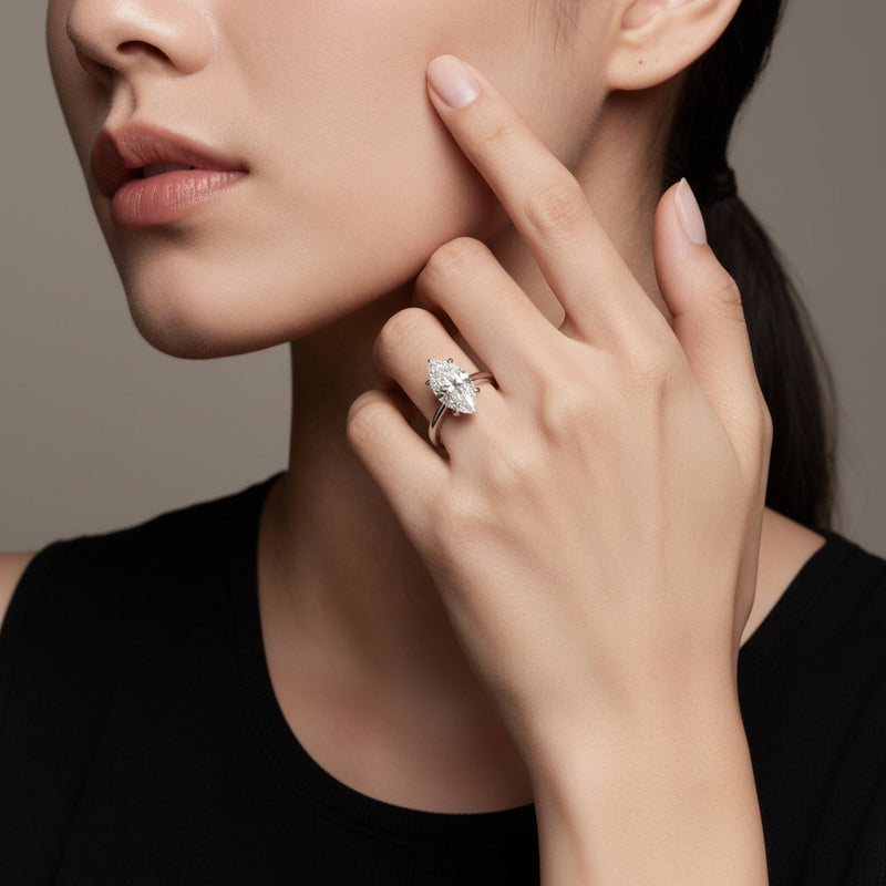 Model wearing marquise knife edge shank solitaire engagement ring
