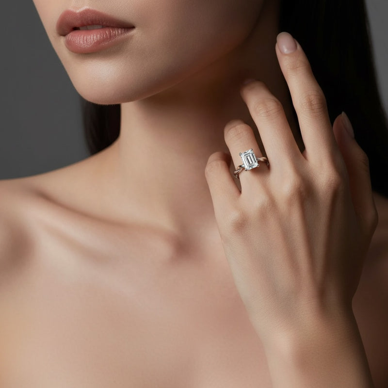 Model wearing emerald twisted shank solitaire engagement ring