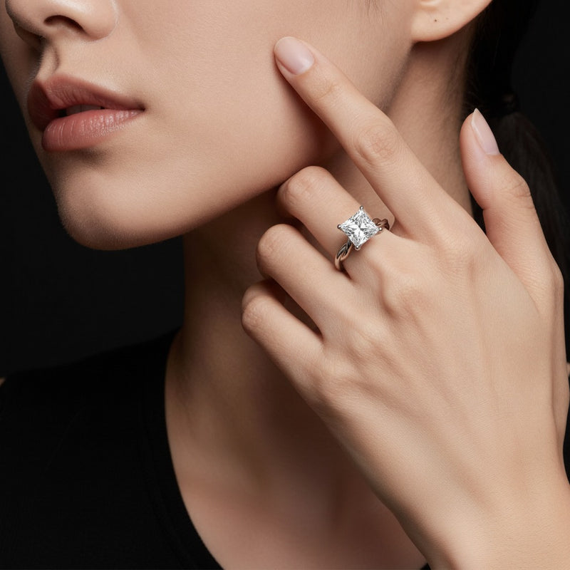 Model wearing princess twisted shank solitaire engagement ring