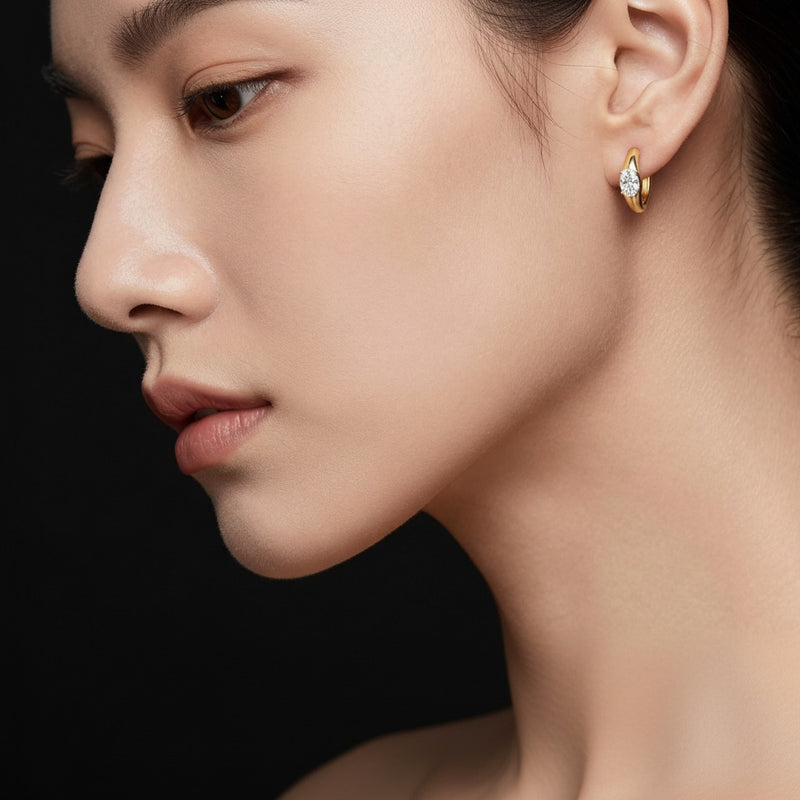 Model wearing oval huggie earrings