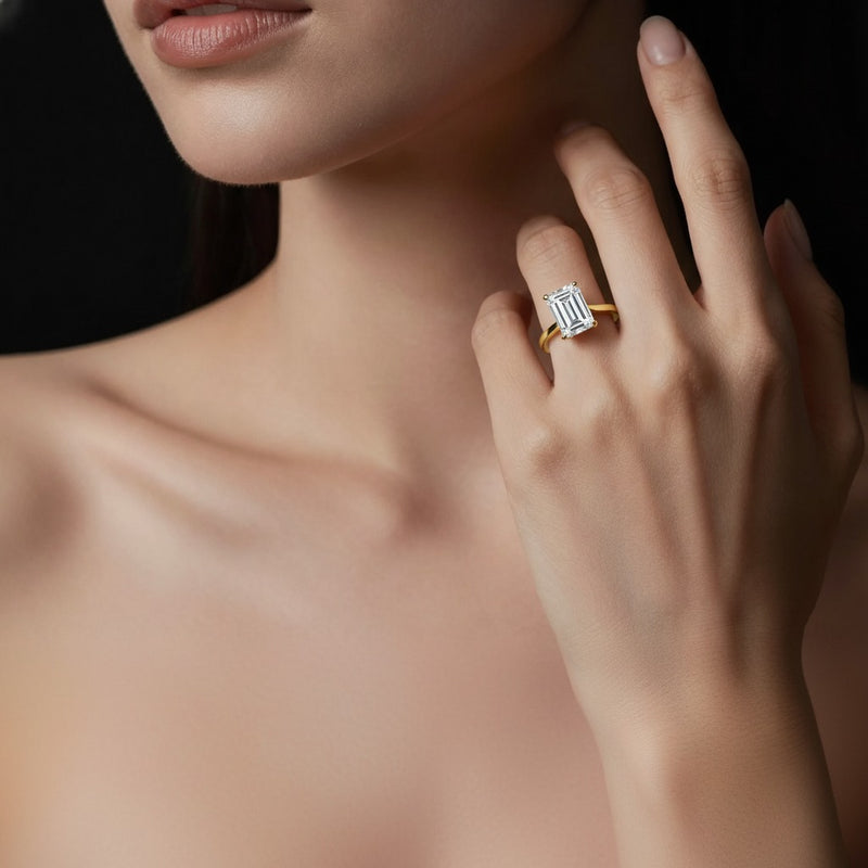 Model wearing emerald accented engagement ring