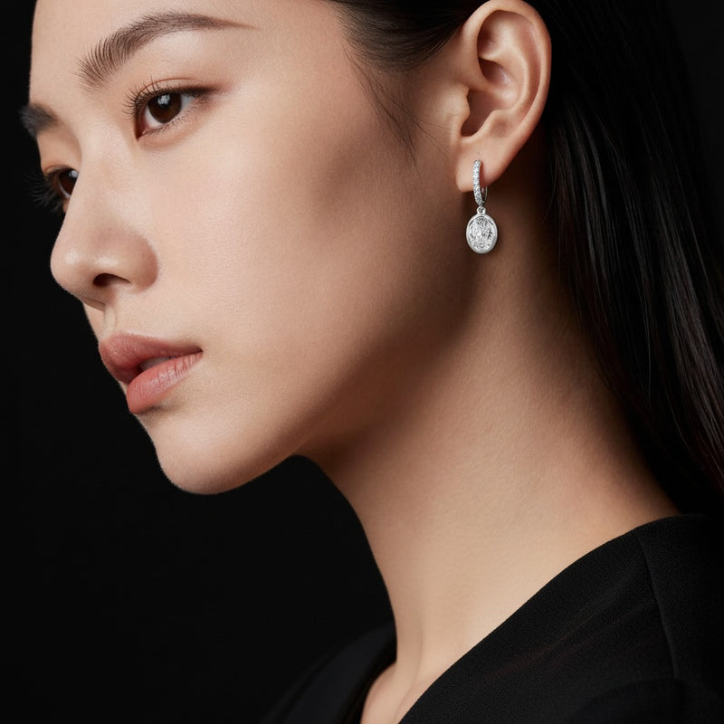 Model wearing oval dangle earrings