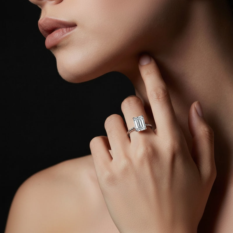 Model wearing emerald petite solitaire engagement ring