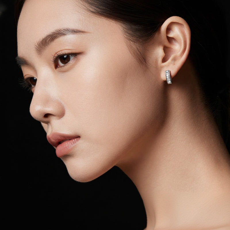 Model wearing oval three stone huggie earrings