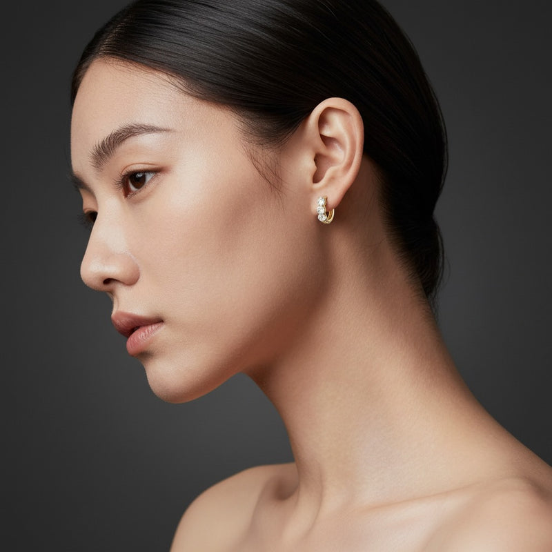 Model wearing round three stone huggie earrings