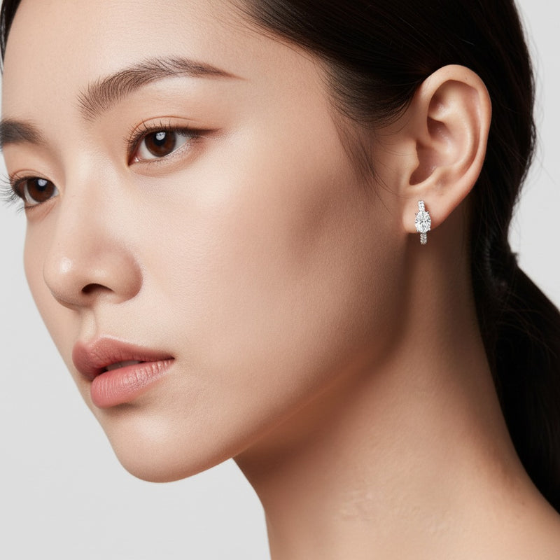 Model wearing oval solitare accent huggie earrings