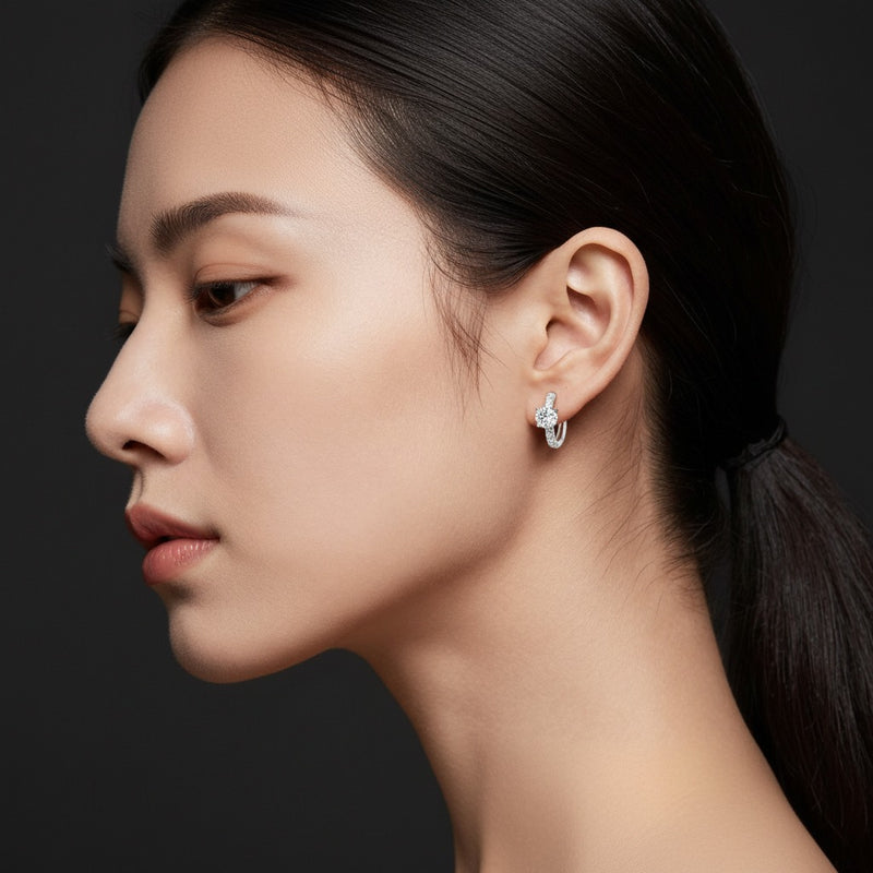 Model wearing round solitare accent huggie earrings
