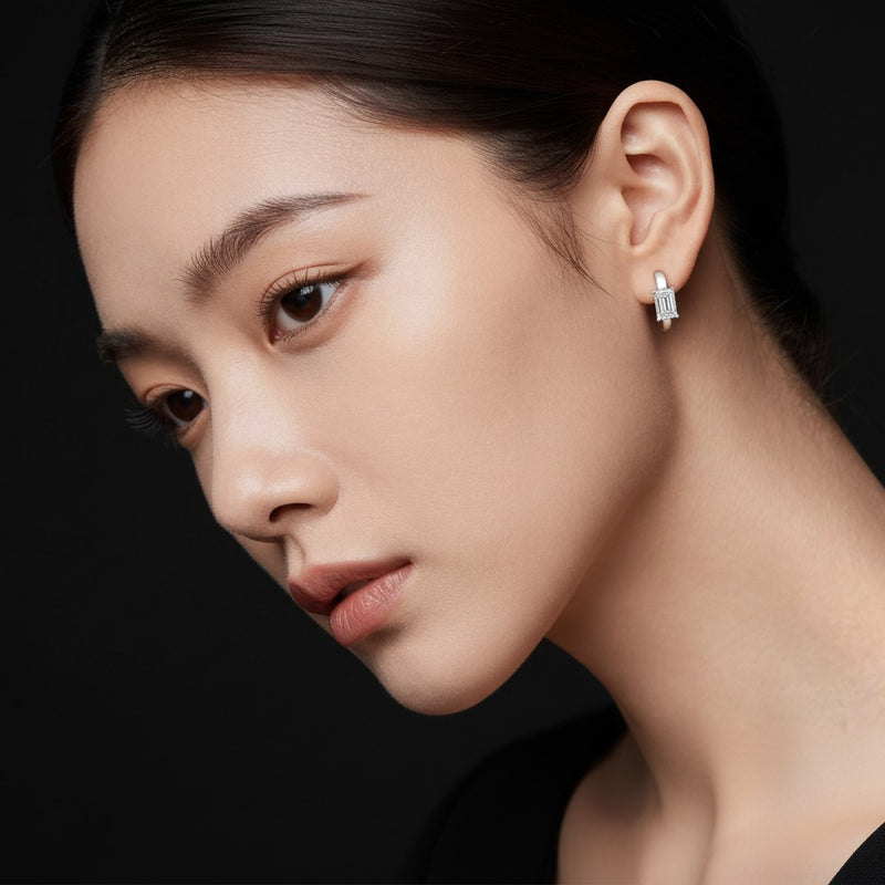 Model wearing emerald solitaire huggie earrings
