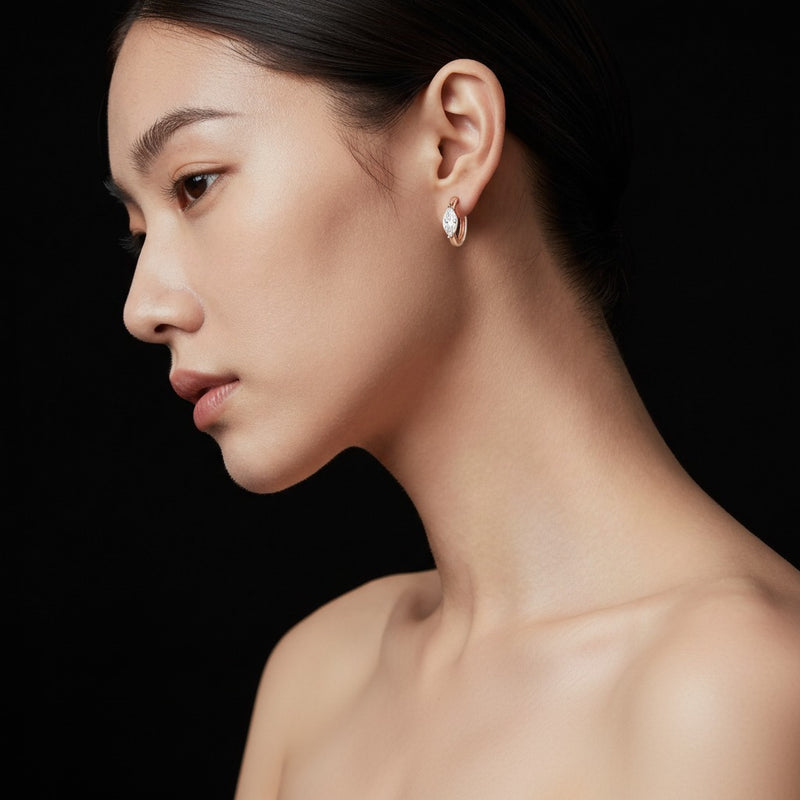Model wearing marquise solitaire huggie earrings