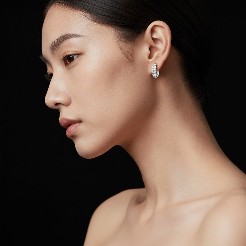 Model wearing round three stone huggie earrings