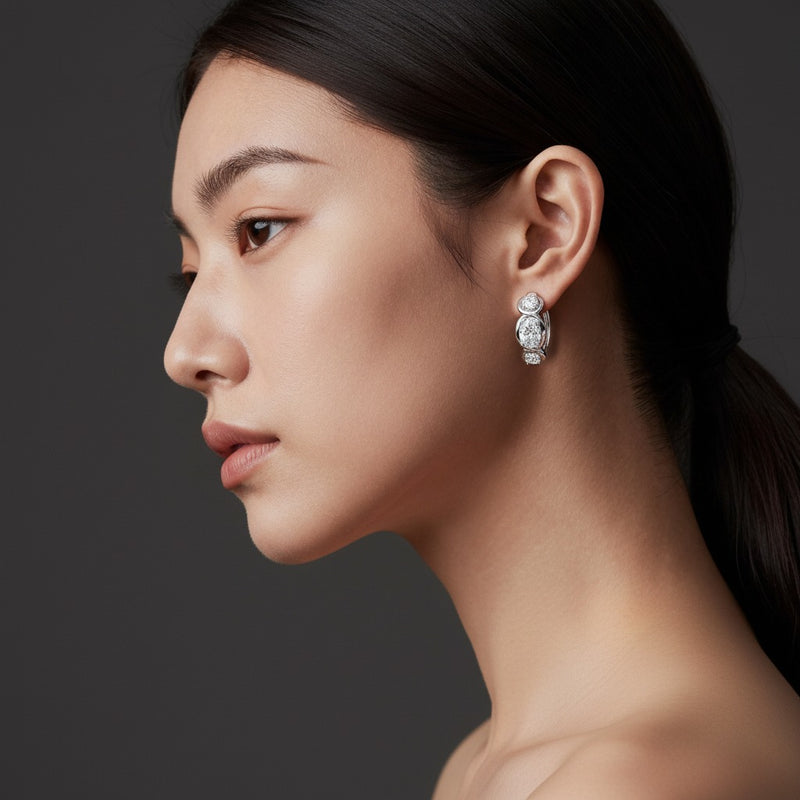 Model wearing oval three stone huggie earrings