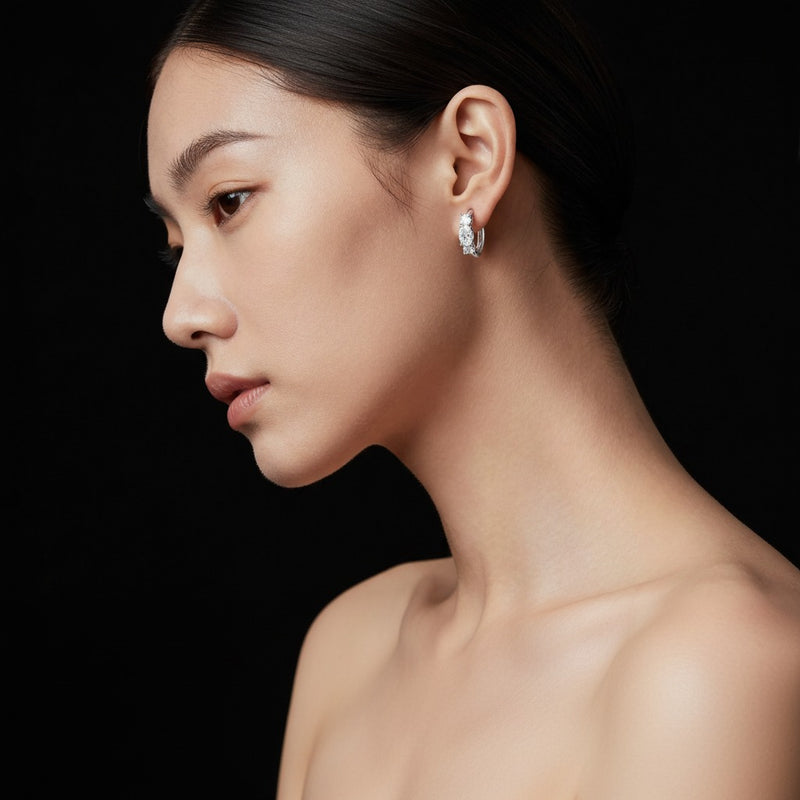 Model wearing oval three stone huggie earrings
