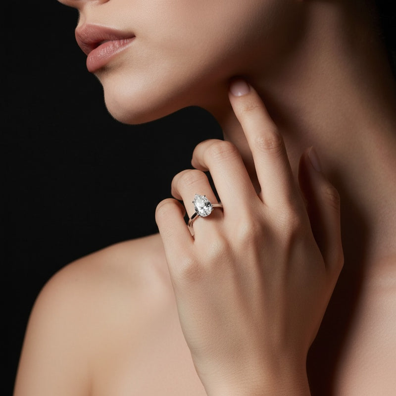 Model wearing pear hidden halo plain shank engagement ring