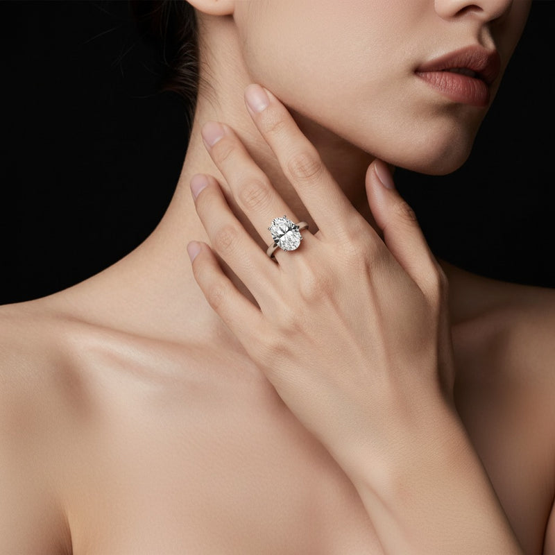 Model wearing oval hidden halo cathedral shank engagement ring