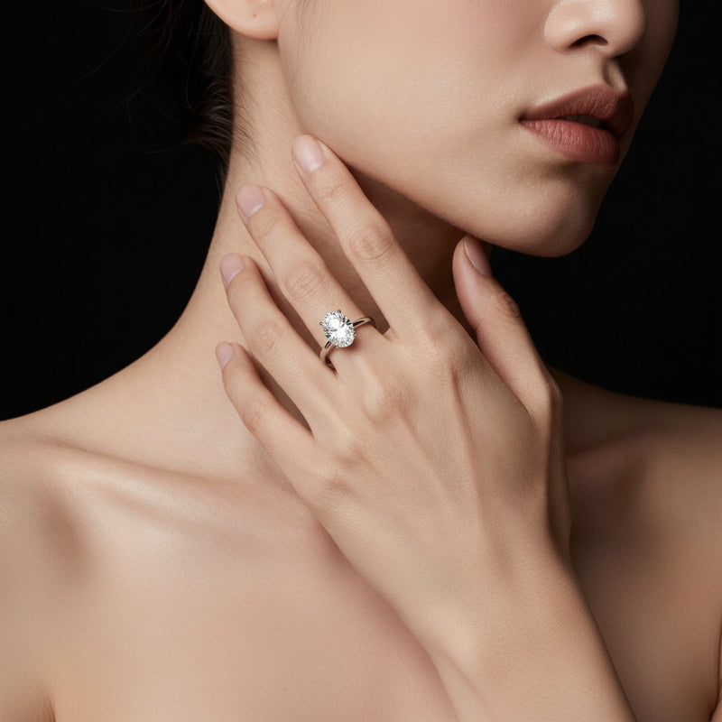 Model wearing oval hidden halo cathedral shank engagement ring