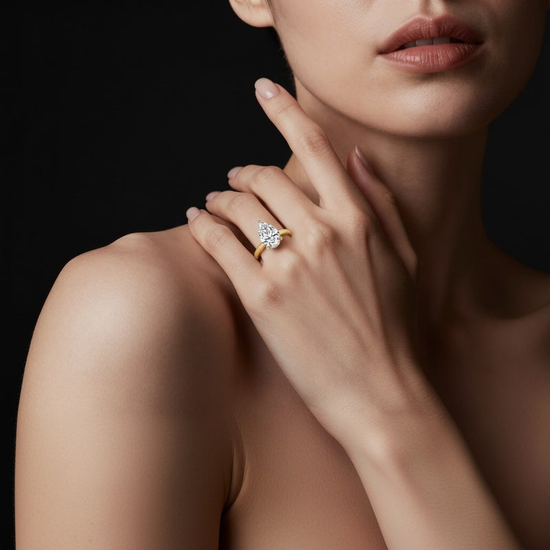 Model wearing pear hidden halo cathedral shank engagement ring