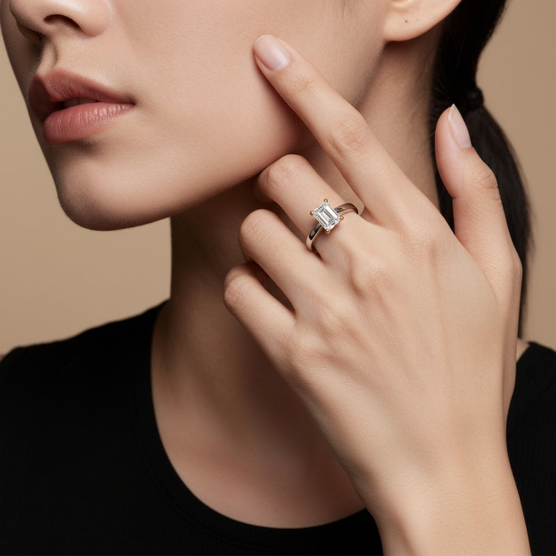 Model wearing emerald two tone twisted basket cathedral shank solitaire ring