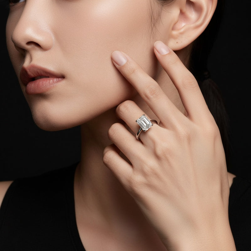 Model wearing emerald knife edge shank solitaire engagement ring