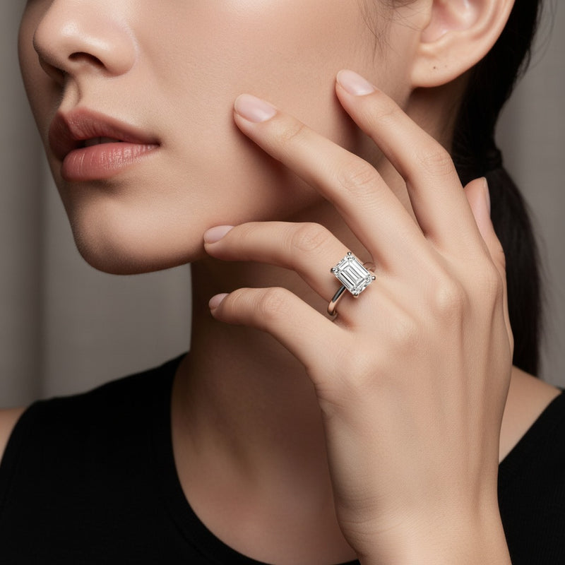 Model wearing emerald knife edge shank solitaire engagement ring