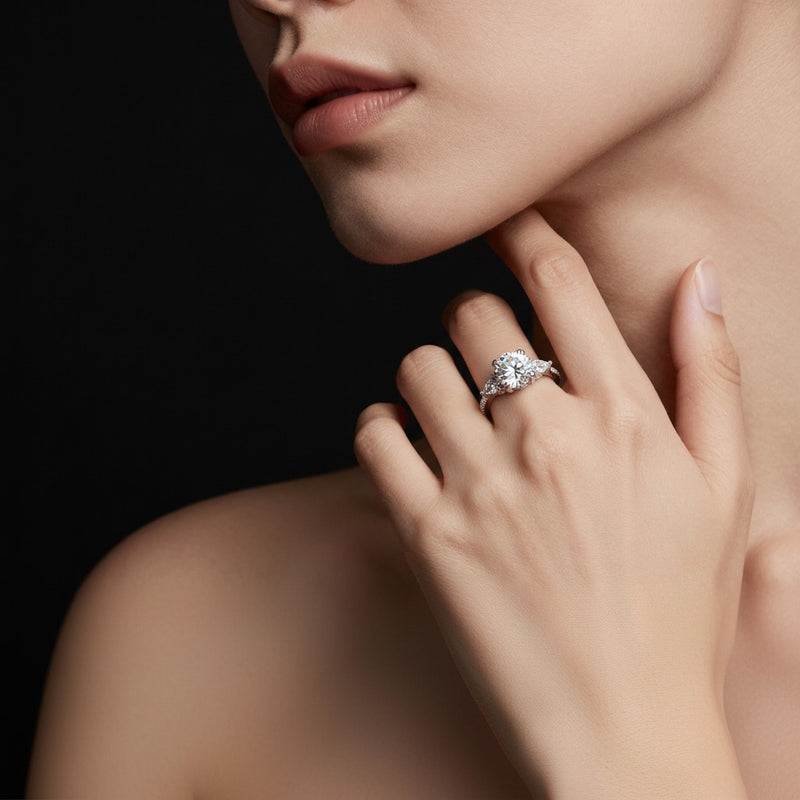 Model wearing round three stone accented engagement ring