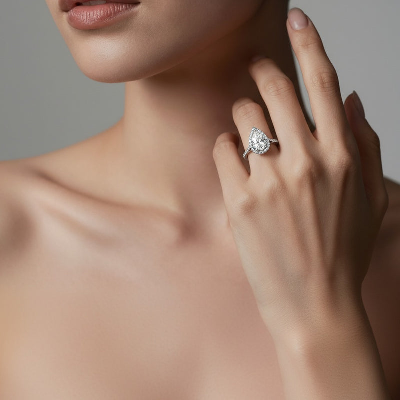 Model wearing pear halo accented engagement ring
