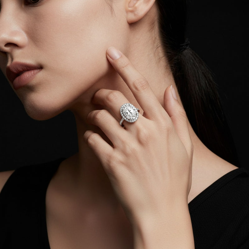 Model wearing oval classic halo accented engagement ring