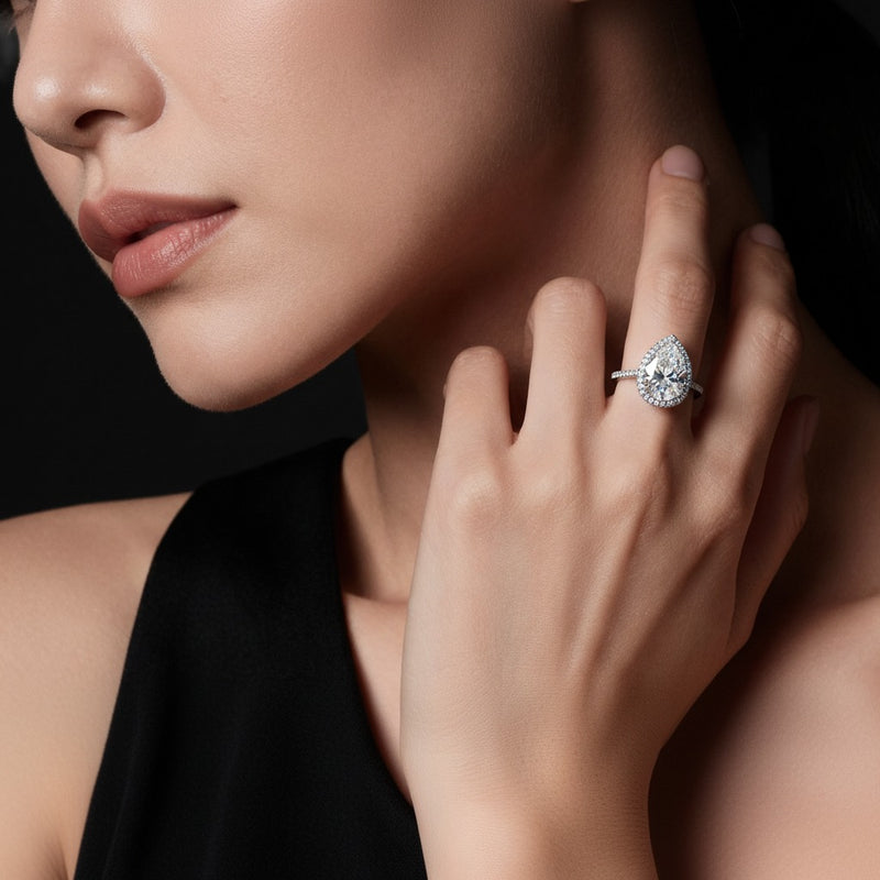 Model wearing pear classic halo accented engagement ring