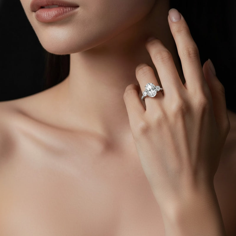 Model wearing oval three stone accented engagement ring