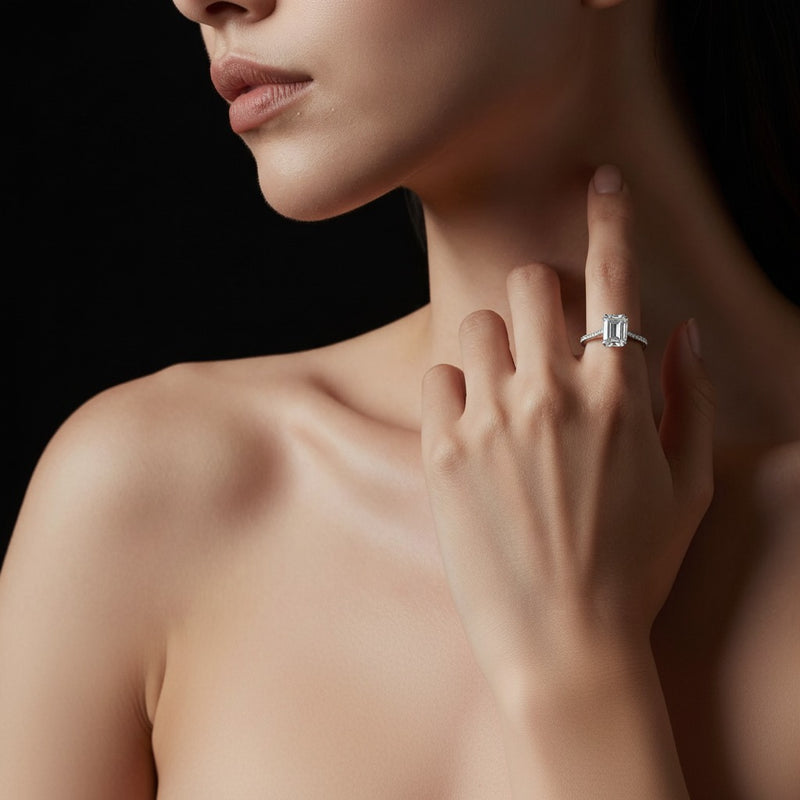 Model wearing emerald accented bridge shank engagement ring
