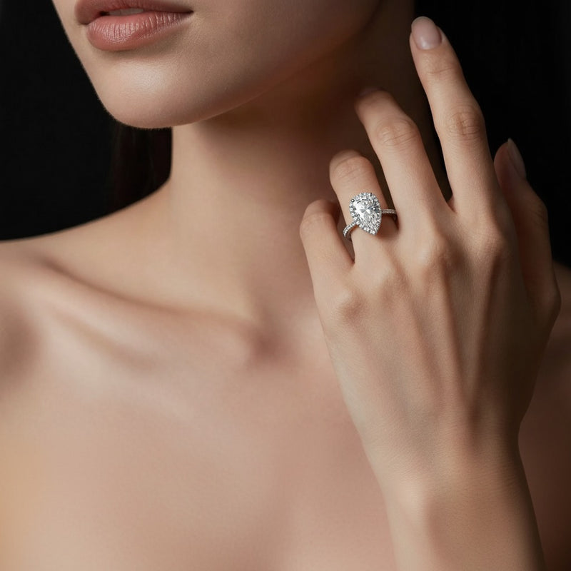 Model wearing pear bolld accented halo engagement ring