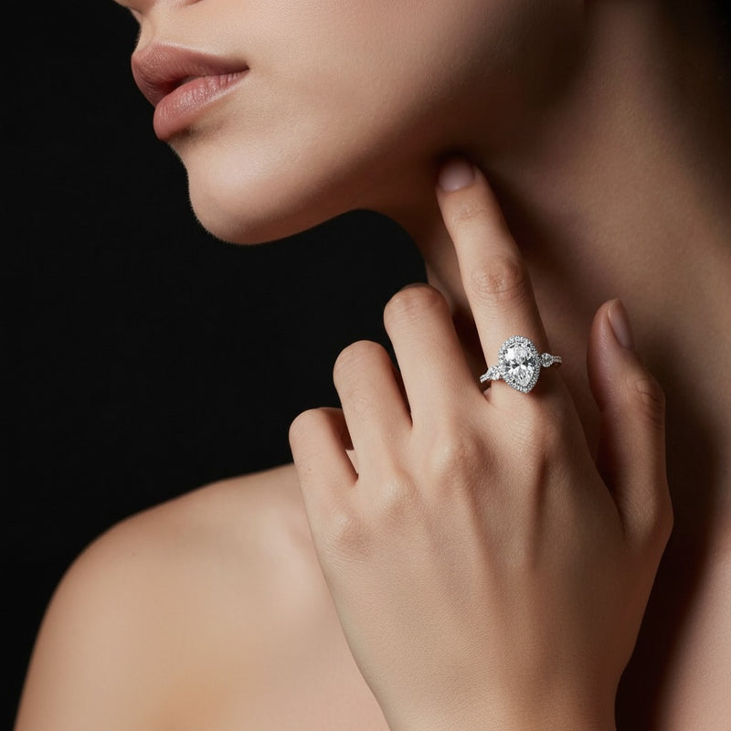 Model wearing pear three stone halo enagement ring