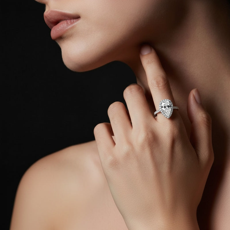 Model wearing pear halo accented engagement ring