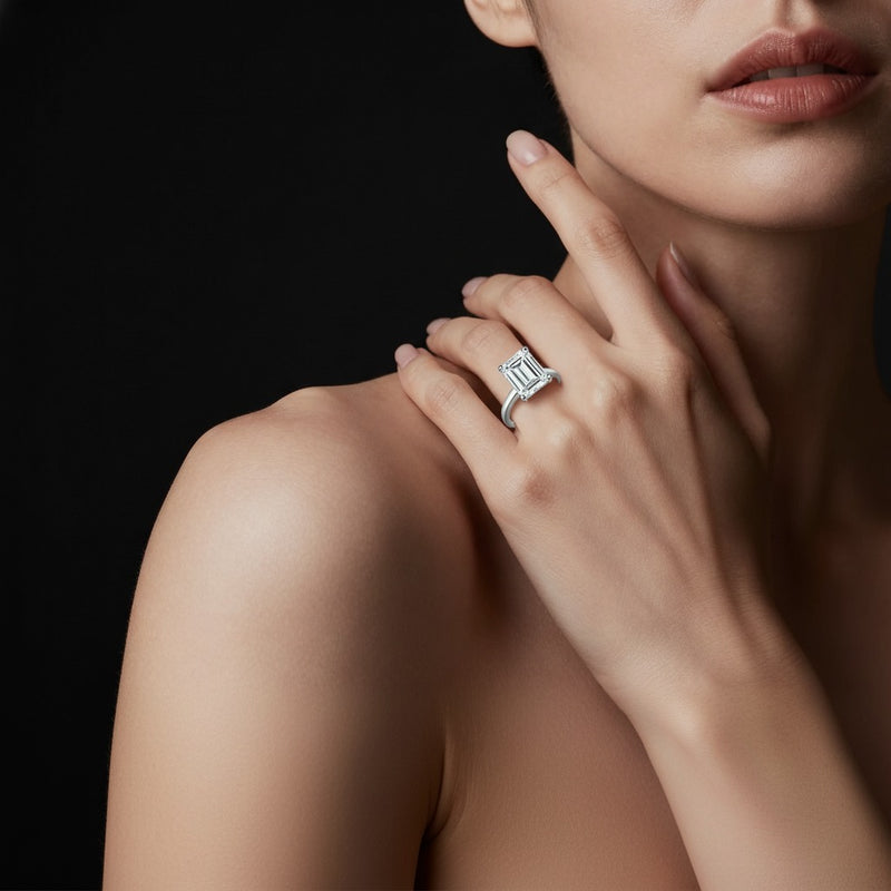 Model wearing emerald classic shank solitaire engagement ring