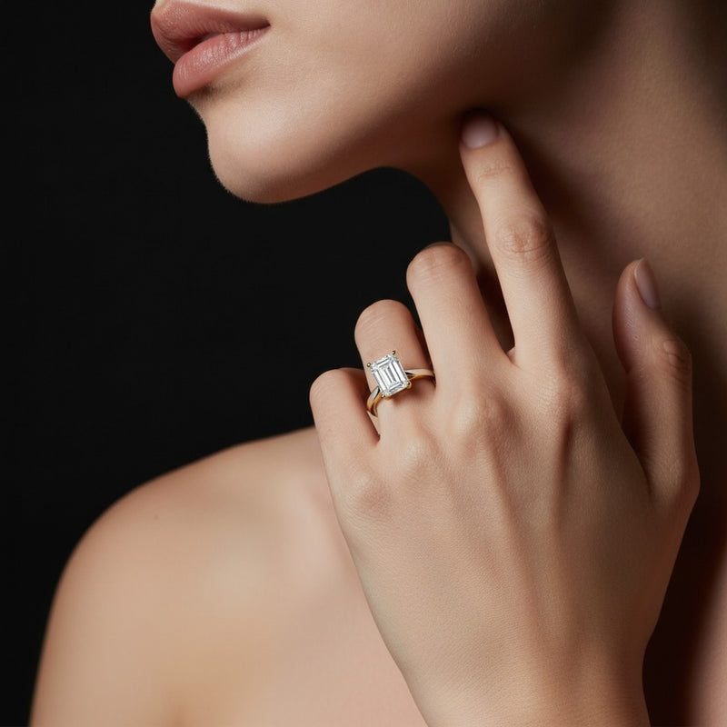 Model wearing emerald two tone cathedral shank engagement ring