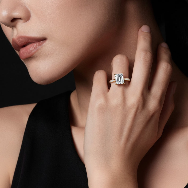 Model wearing emerald two tone cathedral shank engagement ring