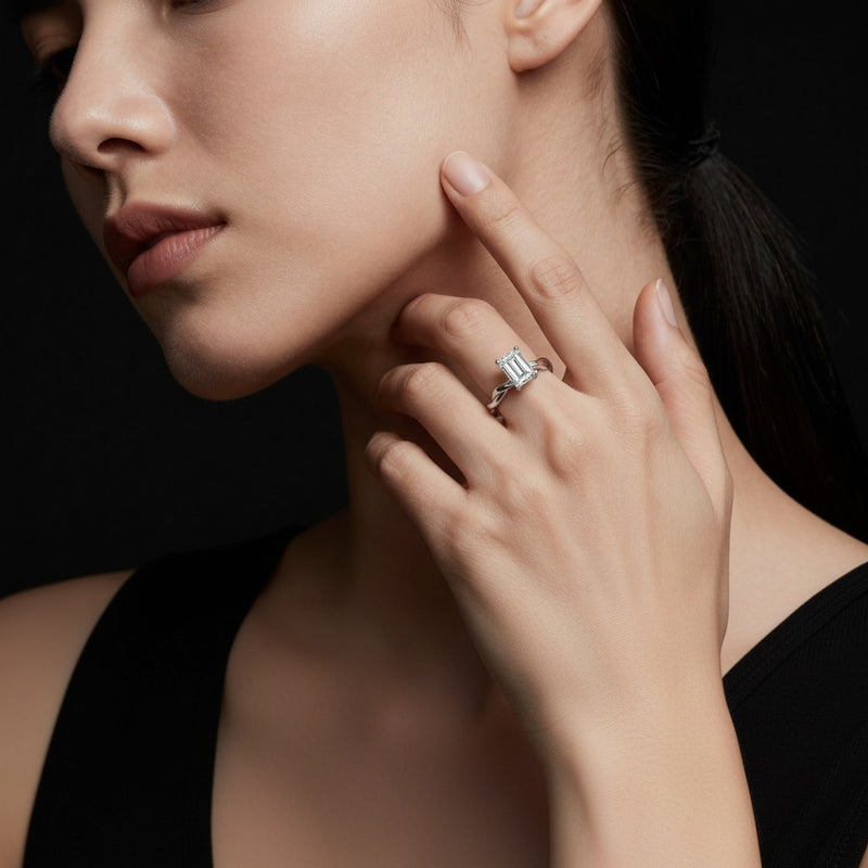 Model wearing emerald twisted shank solitaire engagement ring