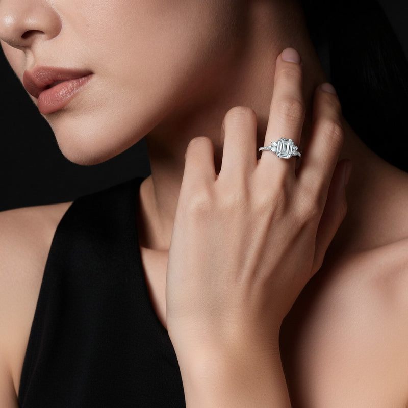 Model wearing emerald east west accented three stone ring