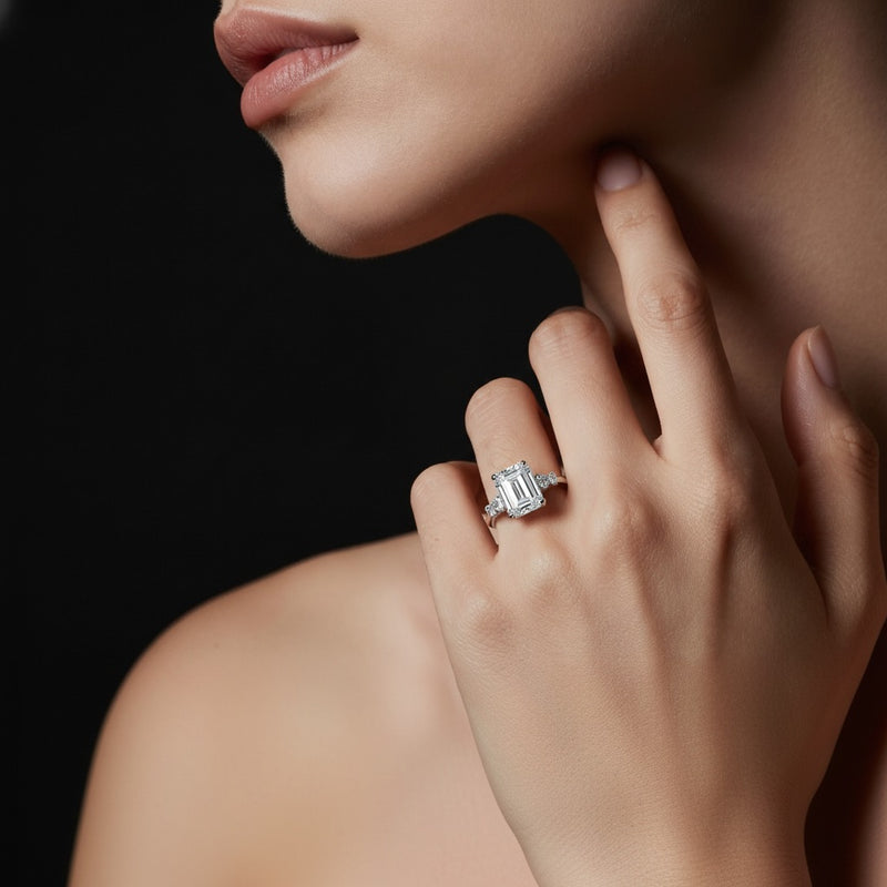 Model wearing emerald east west accented three stone ring