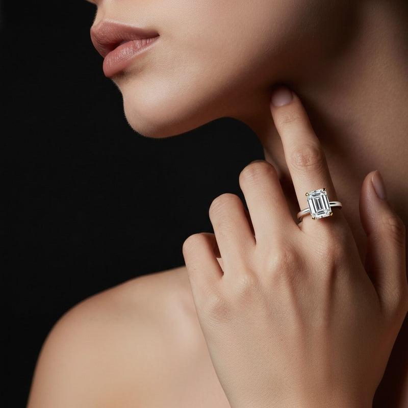 Model wearing emerald solitaire engagement ring