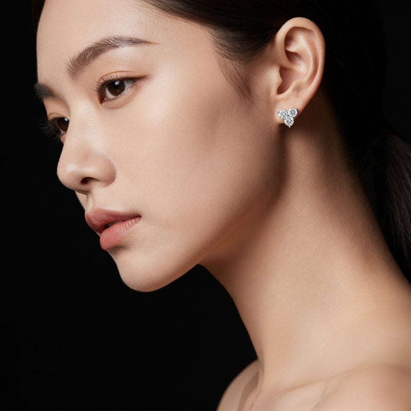 Model wearing round three stone earrings