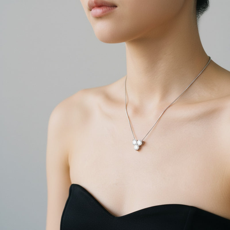 Model wearing round three stone pendant